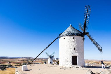 Consuegra, İspanya; 23 Eylül 2025: İspanya 'nın Consuegra kentindeki açık mavi gökyüzünün altında duran tarihi yel değirmenleri
