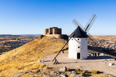Consuegra, İspanya; 23 Eylül 2025: Tarihi yel değirmenleri ve ortaçağ Muela Şatosu İspanya 'nın Consuegra ovalarına tepeden bakmaktadır.