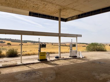 Villalgordo del Marquesado, İspanya; 21 Eylül 2025: Terk edilmiş bir benzin istasyonunun çatısı altında duran eski yakıt pompaları