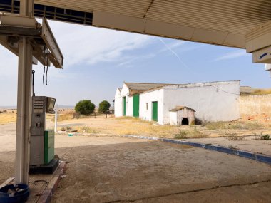 Villalgordo del Marquesado, İspanya; 21 Eylül 2025: Terkedilmiş benzin istasyonu binası ve temiz bir gökyüzü altında kuru bitki örtüsü ile pompalama