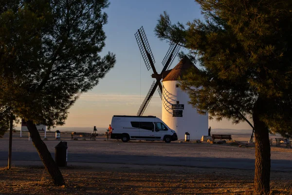Mota del Cuervo, İspanya; 22 Eylül 2025: Mota del Cuervo 'da günbatımında geleneksel bir yel değirmeninin yakınına park edilmiş bir karavan.