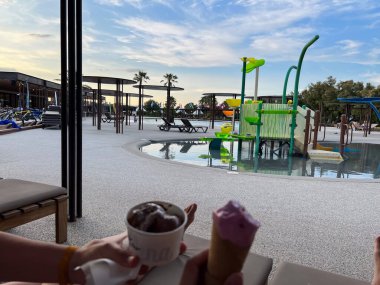 Sant Pere Pescador, İspanya; 23 Haziran 2023: Sant Pere Pescador, İspanya 'da aile dostu bir tatil köyünde rahatlatıcı ve dondurma yiyen kişi