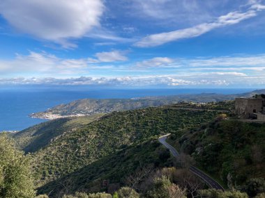 El Port de la Selva, İspanya; 8 Aralık 2020: Uzak bir kıyı kasabası ve mavi Akdeniz ile yeşil tepeler boyunca kıvrımlı yol