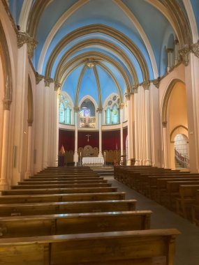 Queralbs, İspanya; 22 Mart 2021: Ahşap sıraların bulunduğu boş kilise iç kısımları, kubbeli mavi bir tavanın altında süslü bir sunağa çıkıyor.