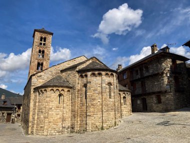 La Vall de Boi, İspanya; 26 Temmuz 2021: Romanesk Santa Maria Kilisesi ve mavi gökyüzü altındaki köy evleri