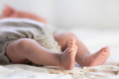 Yumuşak desenli battaniyede dinlenen yeni doğmuş bebek ayakları, yeni hayatı ve huzuru simgeliyor.