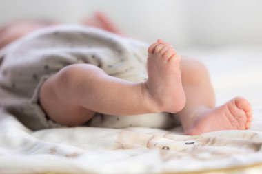 Yumuşak bir battaniyede dinlenen küçük buruşuk tabanlı yeni doğmuş bebek ayakları.