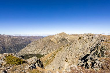 Pireneler yüksek dağ ortamı kayalık yamaçları ve açık mavi gökyüzünü gösteriyor