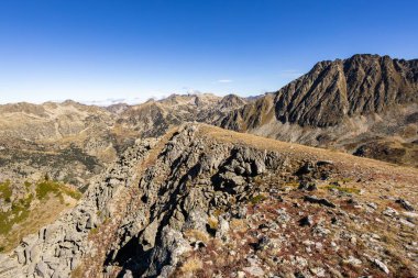 Pireneler açık mavi gökyüzünün altında kayalık ve engebeli bir araziyi gösteriyor.