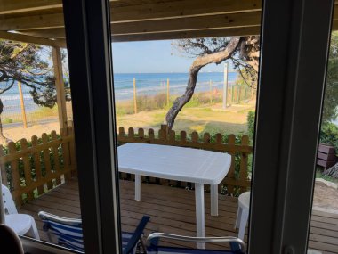 Tarragona, Katalonya 'da plaj ve denize bakan deniz kıyısındaki bir bungalovun terası