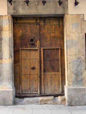Olot, Katalonya, İspanya 'da metal çiviler ve demir tokmak içeren eski ahşap kapı.