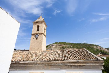 Alcala del Jucar kilise çan kulesi mavi gökyüzünün altında geleneksel İspanyol çatısının üzerinde yükseliyor.