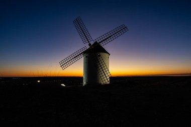 Geleneksel İspanyol yel değirmeni alacakaranlık gökyüzüne karşı duruyor ve güzel bir siluet oluşturuyor.