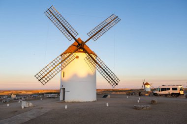 Mota del Cuervo 'daki geleneksel İspanyol yel değirmeni, gün batımında bir karavanla seyahat etmeyi temsil ediyor.