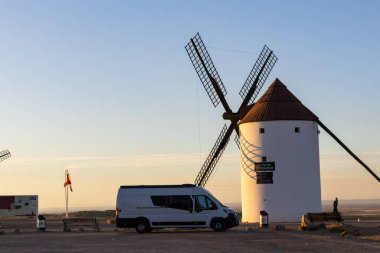 Bir yolculuk sırasında seyahat eden karavan, ikonik bir İspanyol yel değirmeninin yanına park edilmiştir.