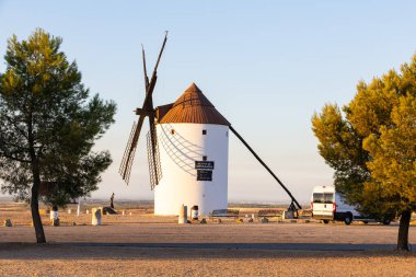 Geleneksel İspanyol yel değirmeni kırsal alanda duruyor sıcak akşam ışığı ile yıkanmış.