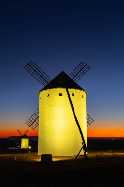 Geleneksel İspanyol yel değirmenleri renkli bir alacakaranlık gökyüzüne karşı aydınlandı