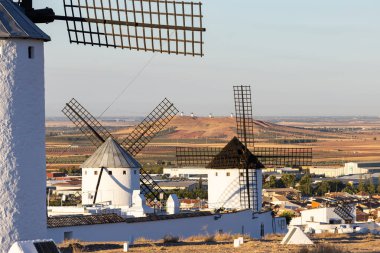 Kasabaya bakan İspanyol yel değirmenleri ve güneşli bir günde La Mancha tarım arazisi
