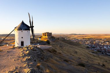 İspanya 'nın Consuegra kasabasına bakan bir tepenin üzerinde duran yel değirmenleri ve şato.