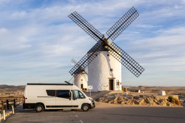 Consuegra, Castilla La Mancha 'daki tarihi yel değirmenlerine hayran kalmış bir karavan.