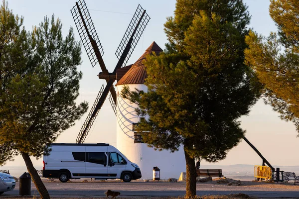 Mota del Cuervo 'da bir İspanyol yel değirmeninin yanına park edilmiş beyaz bir karavan.