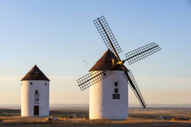 Geleneksel La Mancha rüzgar değirmenleri İspanya kırsalında sıcak bir akşam gökyüzüne karşı duruyor