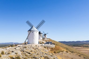 Geleneksel beyaz yel değirmenleri İspanya 'nın Consuegra kentindeki ovalara bakan bir tepenin üzerini benekliyor.
