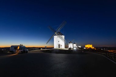 Van gezgini, tarihi yel değirmenlerinin yakınına park etmiş, Consuegra kalesi ve kasaba manzarasının keyfini çıkarıyordu.