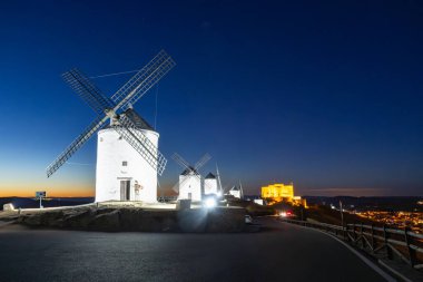 Eski yel değirmenleri bir tepenin üzerinde dikiliyordu. Geceleri aydınlanıyordu.