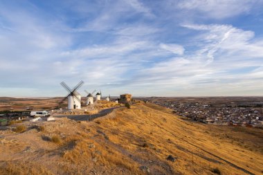 Consuegra yel değirmenleri ve kale harabeleri kırsal kesime ve günbatımında düzlüğe bakıyor.