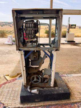 Terk edilmiş bir benzin istasyonunda temiz bir gökyüzünün altında duruyor.