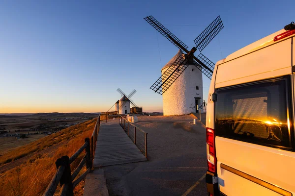 Campervan, Consuegra yel değirmenlerinde altın saat günbatımında bir yolculuk macerası yaşıyor.