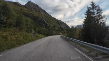 Norveç 'in çarpıcı Lofoten Adaları' ndaki dolambaçlı bir sahil yolunda sürüş yapan karavanın bakış açısı