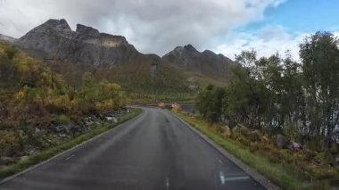 Norveç 'in Senja kentinde sonbahar boyunca fiyort boyunca giden bir karavanın manzarası.