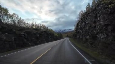 Norveç manzarası boyunca virajlı bir yolda bir karavan sürerken görüntüler