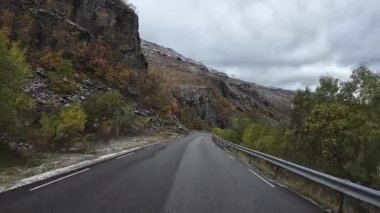Sonbaharda virajlı bir dağ yolunda giden eğlence amaçlı bir araçtan bakış açısı