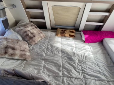 Karavanda yastıklı rahat bir karavan yatağı.