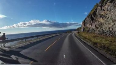 Norveç 'te Reine' e doğru çarpıcı bir sahil yolu kullanan bir karavanın görüntüsü.