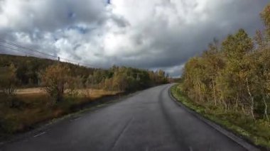 Norveç, Senja 'da sonbahar manzarası boyunca bir karavanı sürerken çekilmiş bir fotoğraf