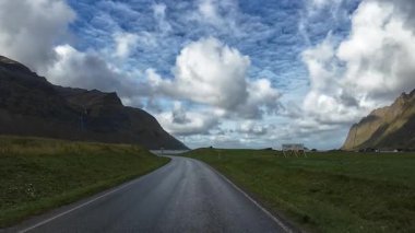 Araç, Norveç 'in Senja adasındaki çarpıcı dağ ve fiyort arazisinden geçiyor.