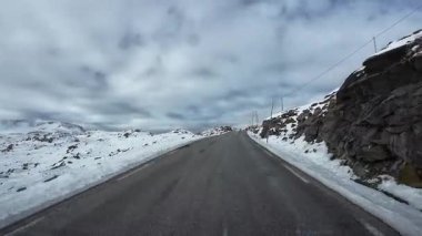 Norveç 'te karla kaplı manzaralarla Sognefjellsvegen dağ yolunda araba sürmek