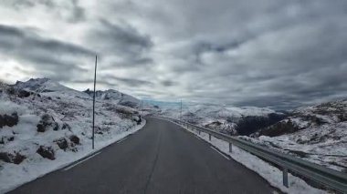 Norveç 'teki karlı bir dağ geçidinde Sognefjellsvegen yolunda araba kullanmak