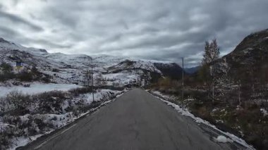 Norveç 'in karlı dağ manzarasını keşfetmek için Sognefjellsvegen yolu boyunca manzaralı bir yolculuk.