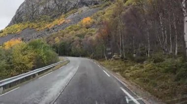 Karavan açısından bulutlu bir sonbahar gününde Norveç dağlarında manzaralı bir yolculuk.