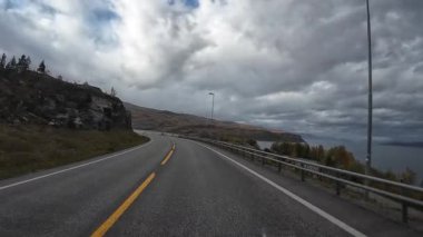 Bakış açısı, güneşli bir günde Norveç 'te bir sahil yolunda bir karavan sürerken çekilmiş.