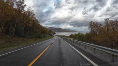 Bakış açısı, güneşli bir günde Norveç 'te bir sahil yolunda bir karavan sürerken çekilmiş.