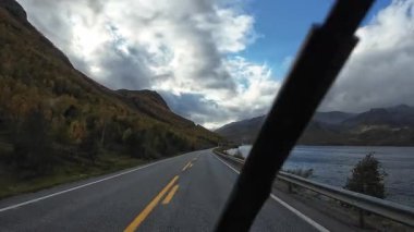 Bakış açısı, güneşli bir günde Norveç 'te bir sahil yolunda bir karavan sürerken çekilmiş.