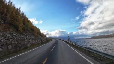 Bakış açısı, güneşli bir günde Norveç 'te bir sahil yolunda bir karavan sürerken çekilmiş.