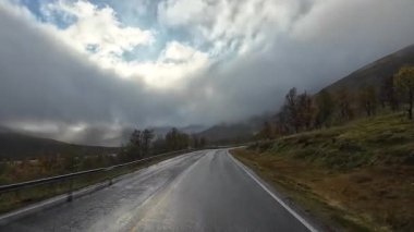 Bakış açısı, güneşli bir günde Norveç 'te bir sahil yolunda bir karavan sürerken çekilmiş.