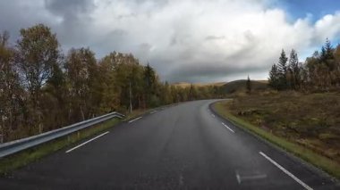 Bakış açısı, güneşli bir günde Norveç 'te bir sahil yolunda bir karavan sürerken çekilmiş.